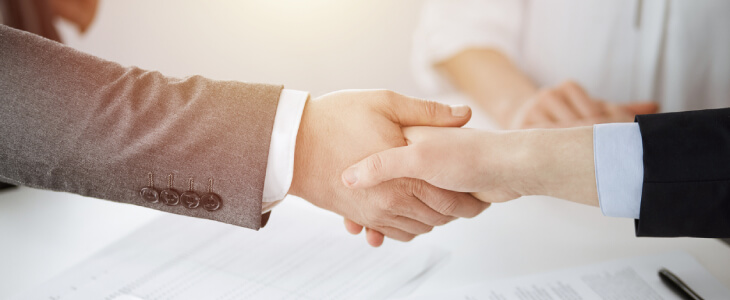 Close up of two people shaking hands in a contract