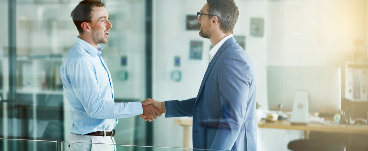 Two businessmen shaking hands in an office