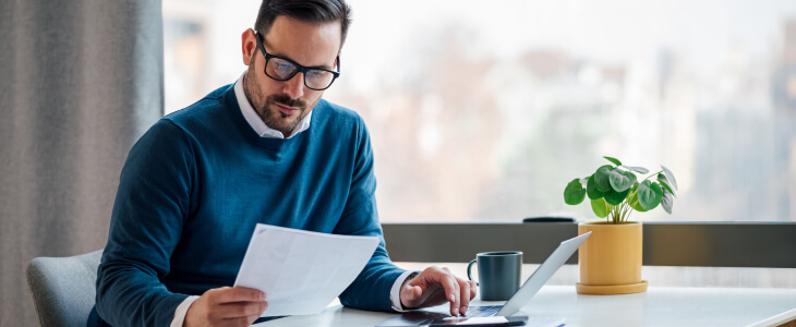 Man in sweater and glasses filing business formation paperwork